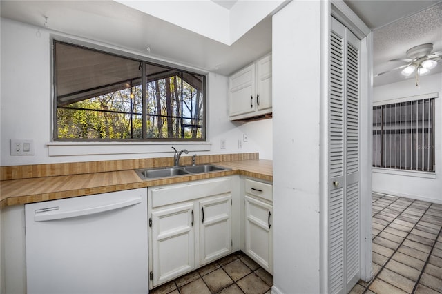 kitchen featuring a sink, dishwasher, light countertops, and a healthy amount of sunlight