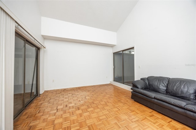 living room with baseboards and a towering ceiling