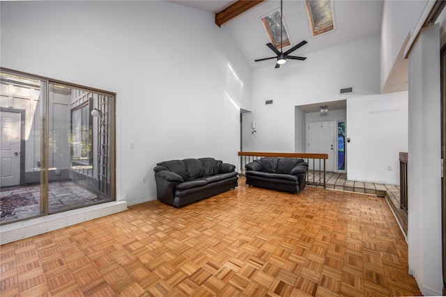 interior space with visible vents, beam ceiling, high vaulted ceiling, a ceiling fan, and baseboards