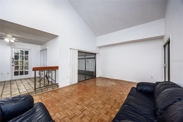 living area with baseboards, high vaulted ceiling, and ceiling fan