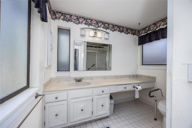 bathroom with vanity, baseboards, a stall shower, tile patterned flooring, and toilet