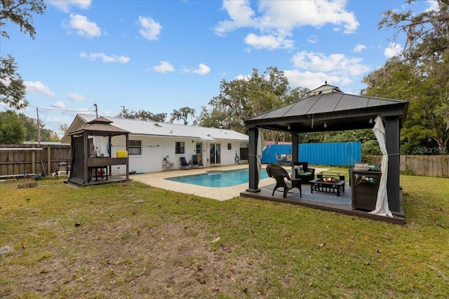 view of pool with a gazebo, a yard, and a fire pit