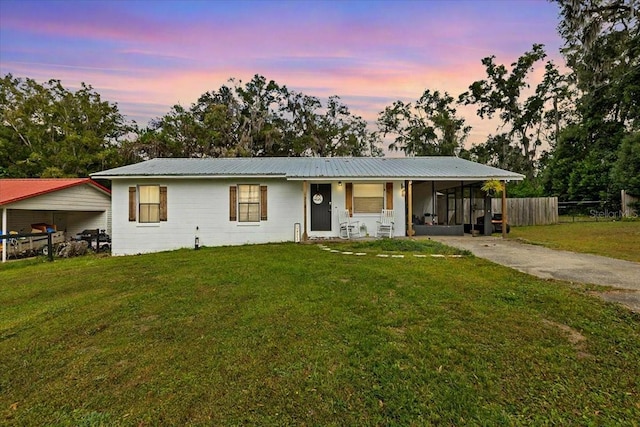 ranch-style home featuring a yard and a carport