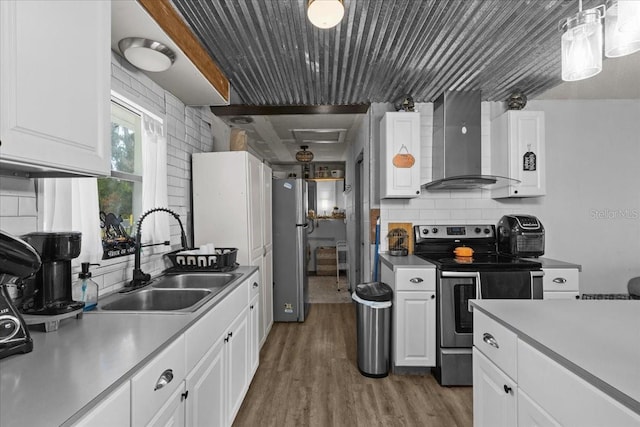 kitchen featuring white cabinetry, appliances with stainless steel finishes, and wall chimney exhaust hood