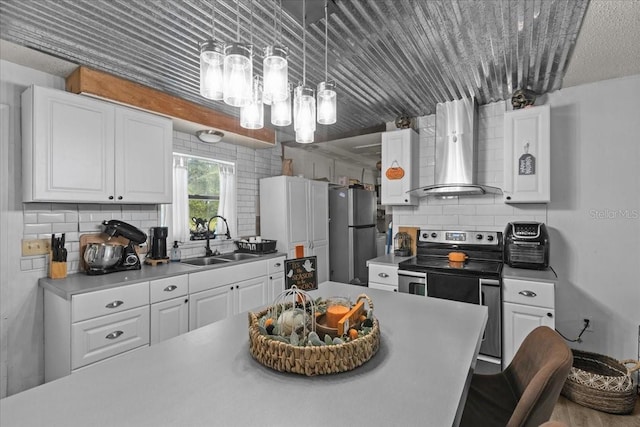 kitchen featuring appliances with stainless steel finishes, wall chimney exhaust hood, sink, and white cabinetry