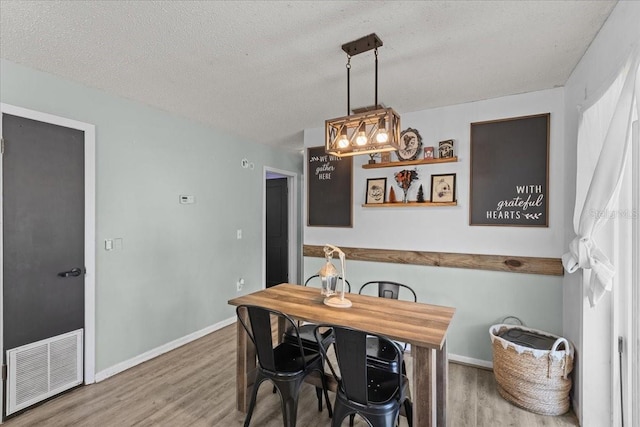 dining area featuring a textured ceiling and hardwood / wood-style floors