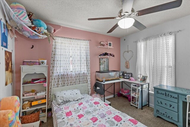 carpeted bedroom with ceiling fan and a textured ceiling