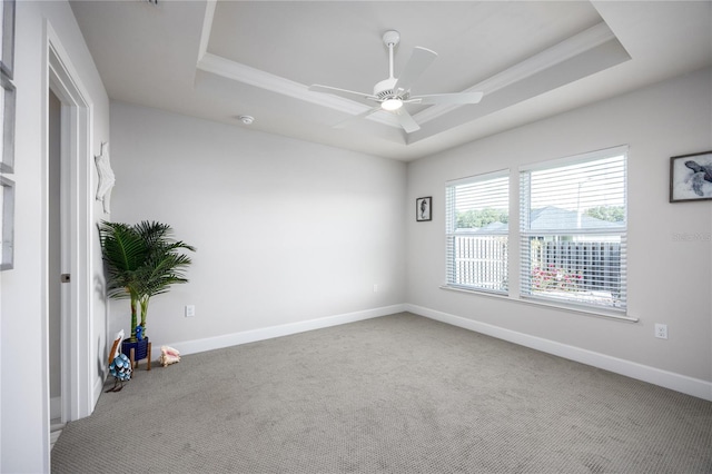 spare room featuring ceiling fan, a tray ceiling, and carpet floors