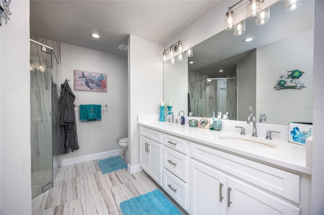 bathroom with toilet, a shower with shower door, and vanity