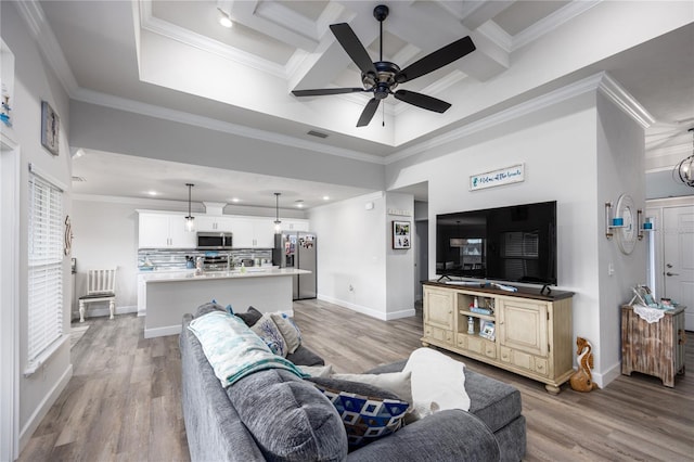 living room featuring hardwood / wood-style floors, crown molding, coffered ceiling, and ceiling fan