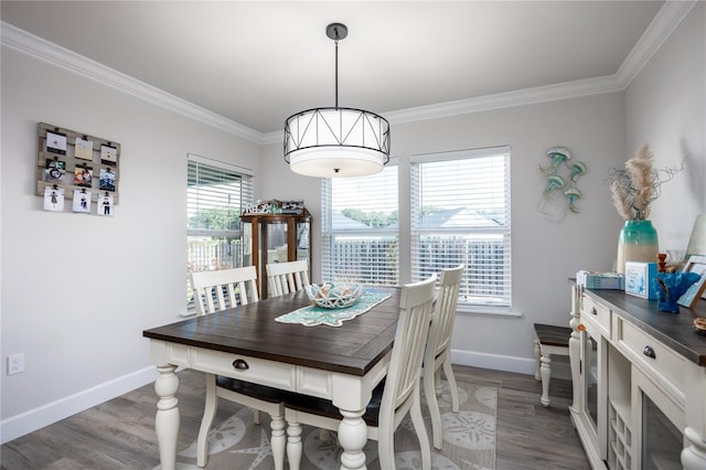 dining area featuring dark hardwood / wood-style flooring, ornamental molding, and plenty of natural light