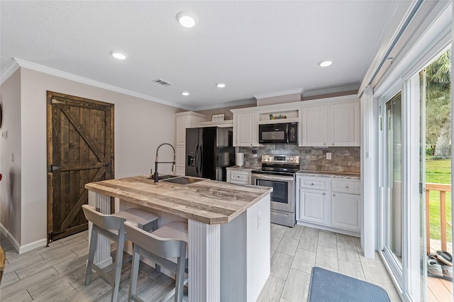 kitchen featuring black appliances, a wealth of natural light, sink, and white cabinets