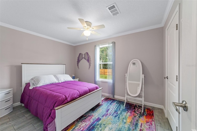 bedroom with ceiling fan, light wood-type flooring, a textured ceiling, and ornamental molding