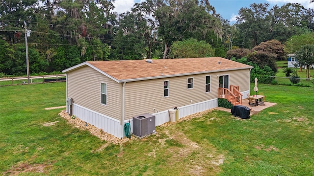 view of side of home with a lawn, a patio, and central AC unit