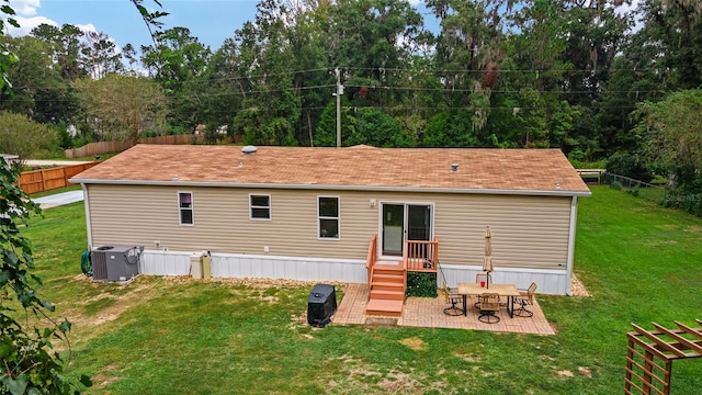 rear view of property with a patio area, a yard, and cooling unit