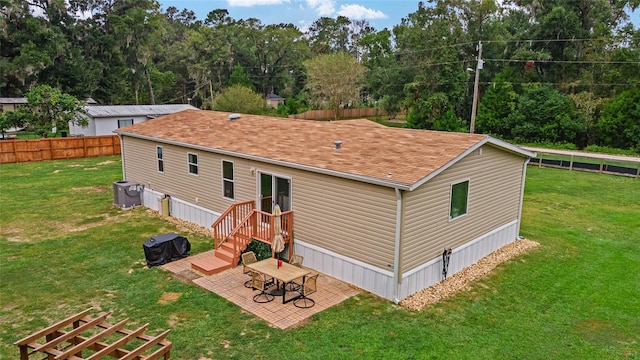 rear view of property with a yard and a patio