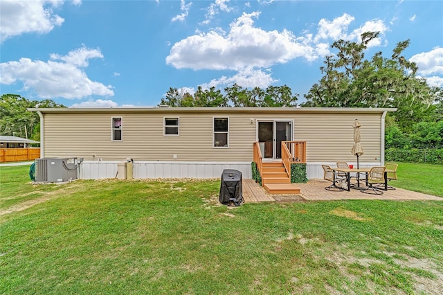 back of property with a yard, a patio area, and cooling unit