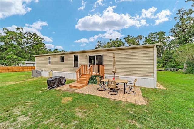 back of property with central AC, a yard, and a patio