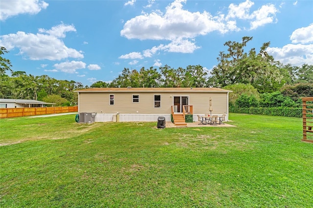 rear view of property featuring a patio and a lawn