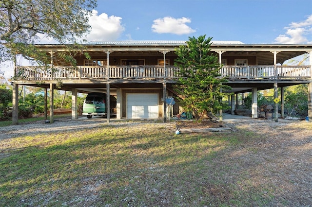 rear view of property with a deck, a garage, and a carport