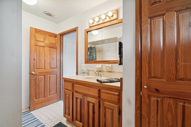 bathroom featuring vanity, walk in shower, and tile patterned flooring