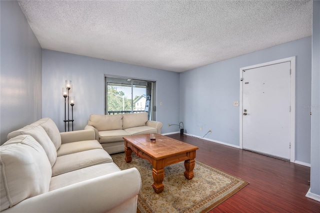 living room featuring dark wood-type flooring and a textured ceiling