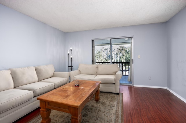 living room featuring dark wood-type flooring and a textured ceiling