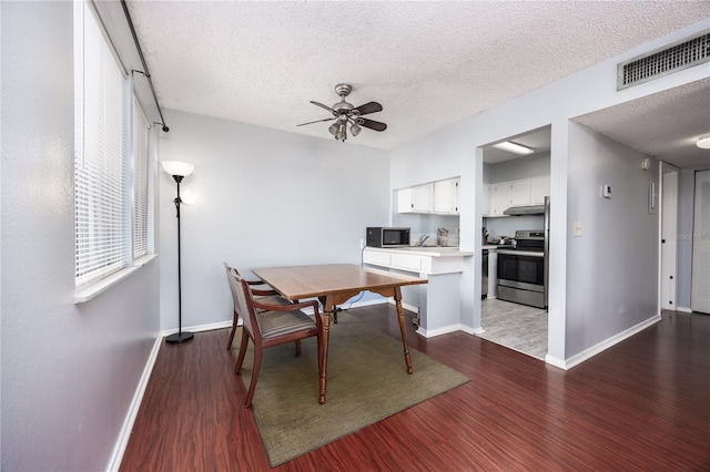 dining room with sink, a textured ceiling, hardwood / wood-style flooring, and ceiling fan