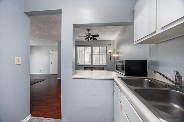 kitchen featuring sink, a textured ceiling, white cabinetry, ceiling fan, and dark hardwood / wood-style floors