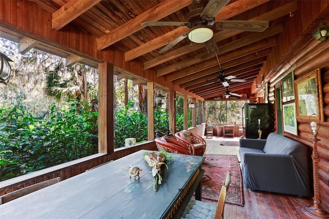 unfurnished sunroom featuring vaulted ceiling with beams, wooden ceiling, and ceiling fan