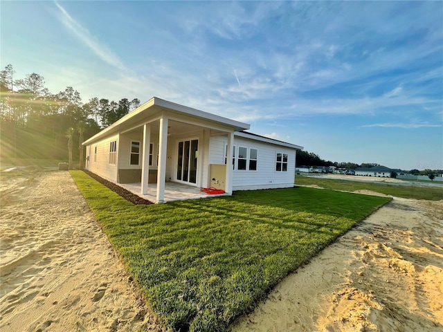 back of property with a patio, ceiling fan, and a yard