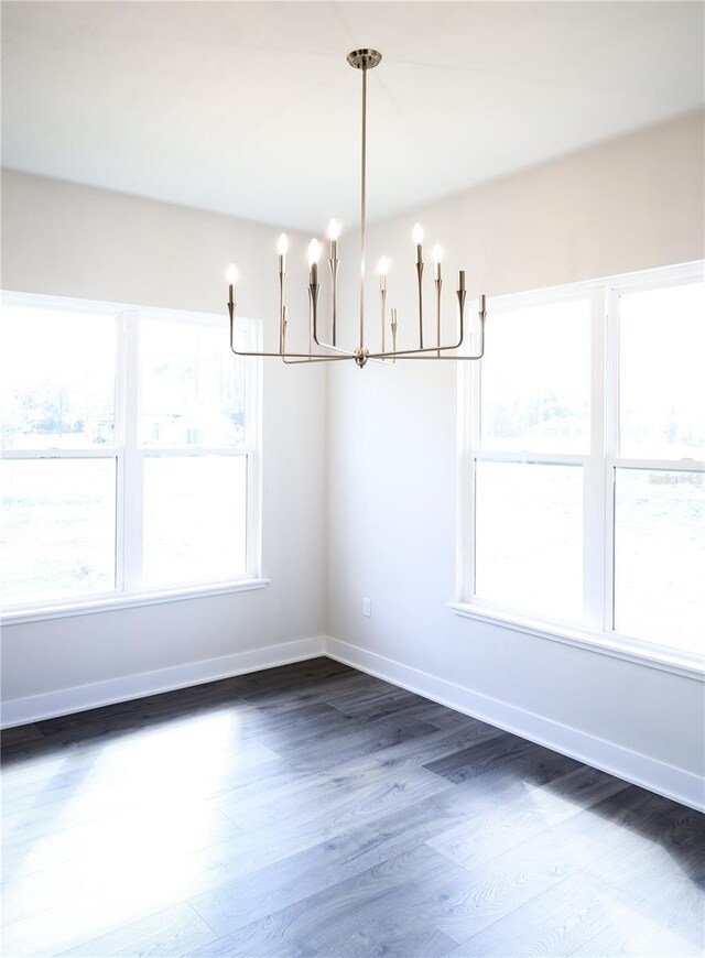 840 SW 144th Dr, Newberry, FL 32669 - unfurnished dining area featuring a chandelier, dark wood-style floors, and baseboards