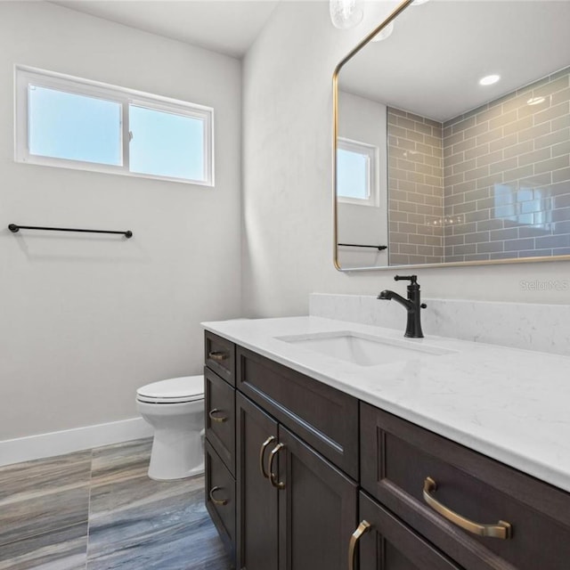 bathroom with vanity, toilet, and wood-type flooring