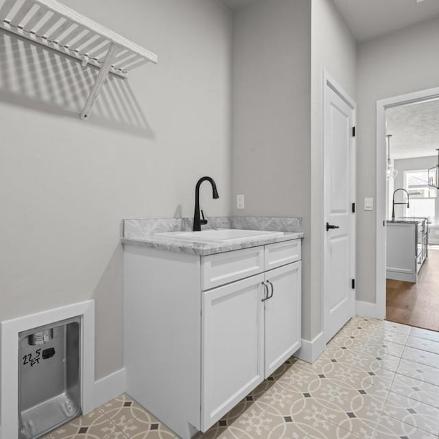 laundry room featuring sink and light wood-type flooring