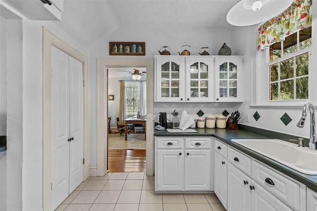 kitchen with sink, white cabinetry, a textured ceiling, and a healthy amount of sunlight