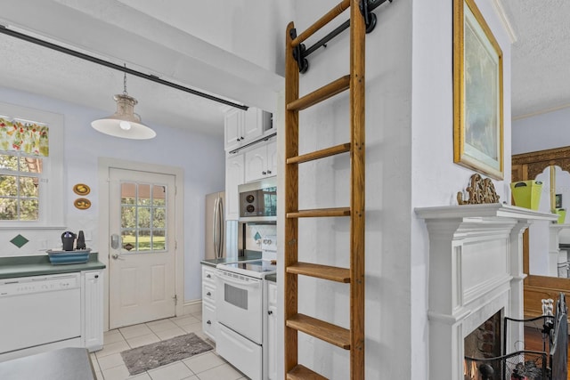 kitchen with white appliances, a textured ceiling, pendant lighting, white cabinets, and light tile patterned floors