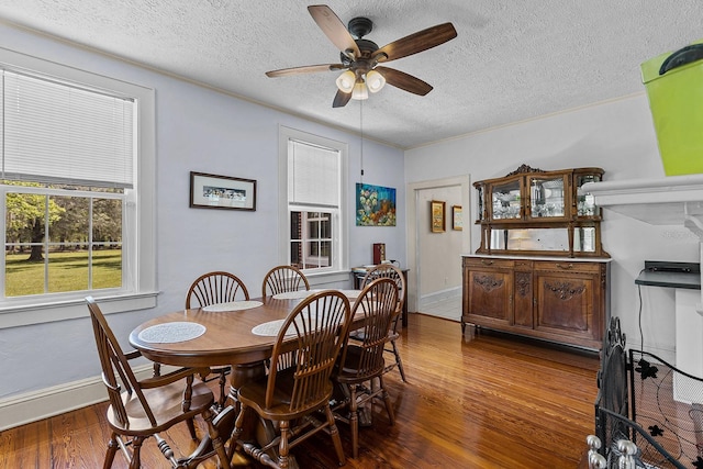 dining area with a textured ceiling, dark hardwood / wood-style floors, and ceiling fan