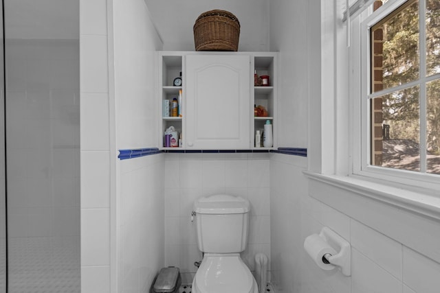 bathroom featuring tile walls and toilet