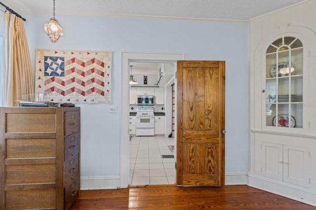 hall featuring ornamental molding, a textured ceiling, and hardwood / wood-style flooring