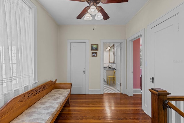 interior space with crown molding, sink, dark wood-type flooring, and ceiling fan