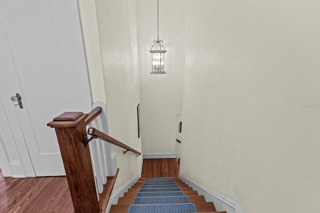 stairs with a chandelier and wood-type flooring