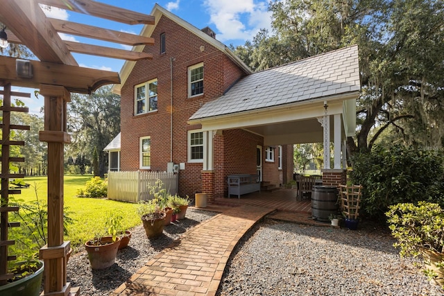 view of side of home featuring a lawn and a pergola