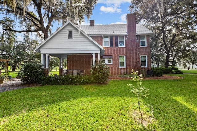 rear view of property with a lawn