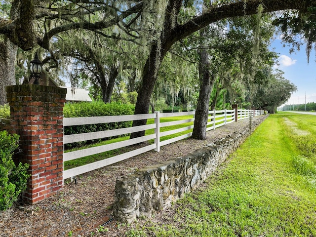 view of gate with a lawn