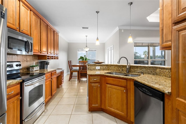 kitchen featuring a healthy amount of sunlight, stainless steel appliances, sink, and pendant lighting