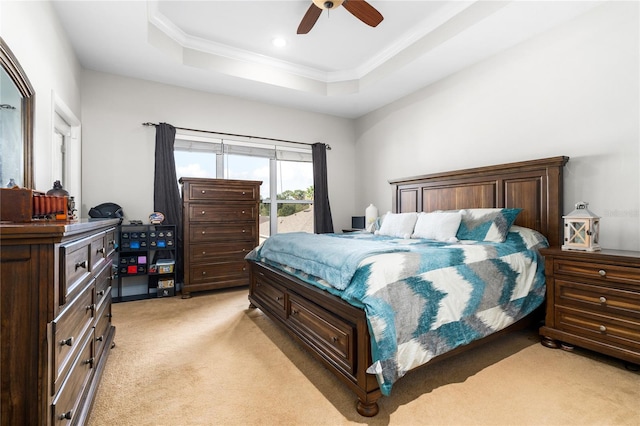 bedroom with ceiling fan, a raised ceiling, ornamental molding, and light colored carpet