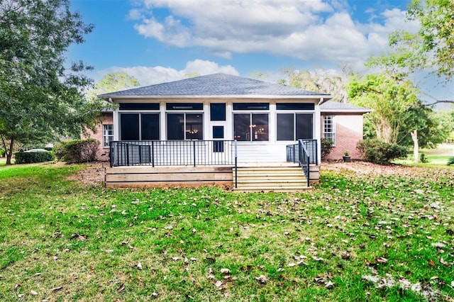 back of property with a lawn and a sunroom