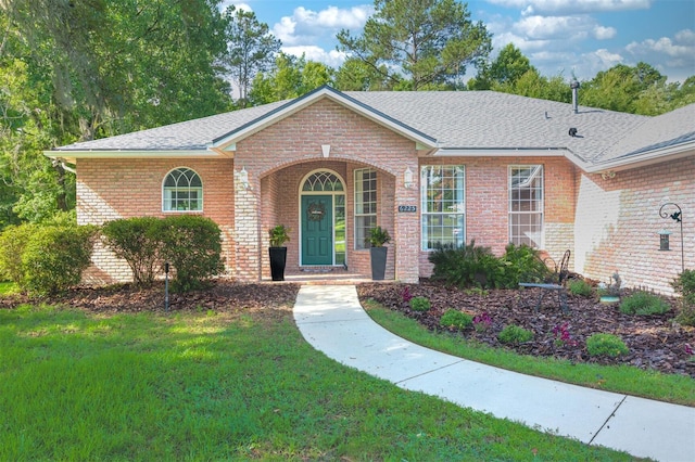 6225 NW 105th Ave, Alachua, FL 32615 - view of front of property with brick siding, a front yard, and roof with shingles