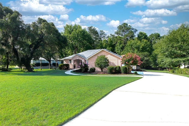 6225 NW 105th Ave, Alachua, FL 32615 - single story home with a front lawn, brick siding, and curved driveway