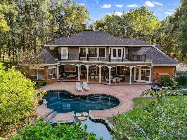 back of house featuring a balcony, french doors, and a patio area